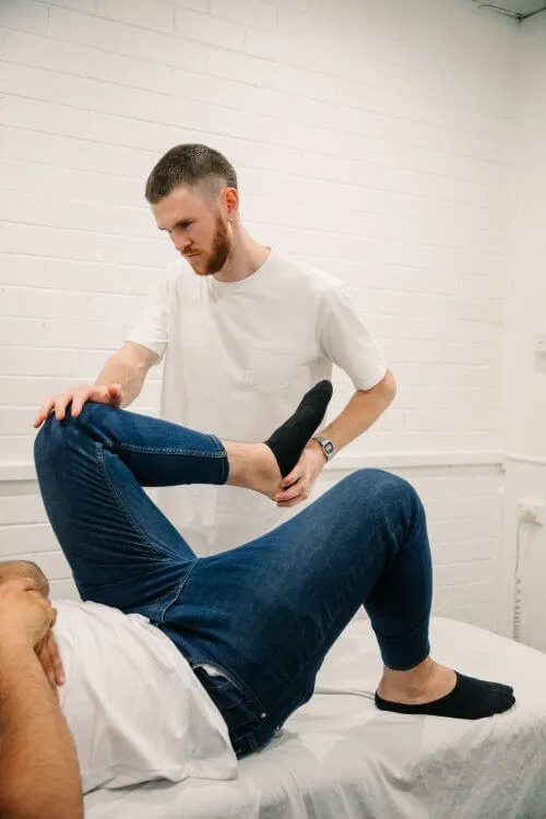 A physiotherapist working with a patient in a bright treatment room